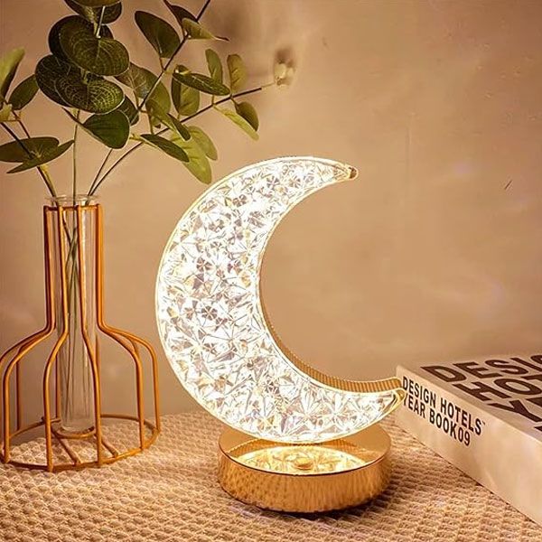 Moon table lamp glowing on a nightstand in a bedroom