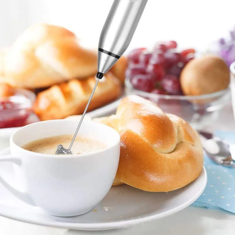 Milk frother creating thick foam in a glass of milk for cappuccino